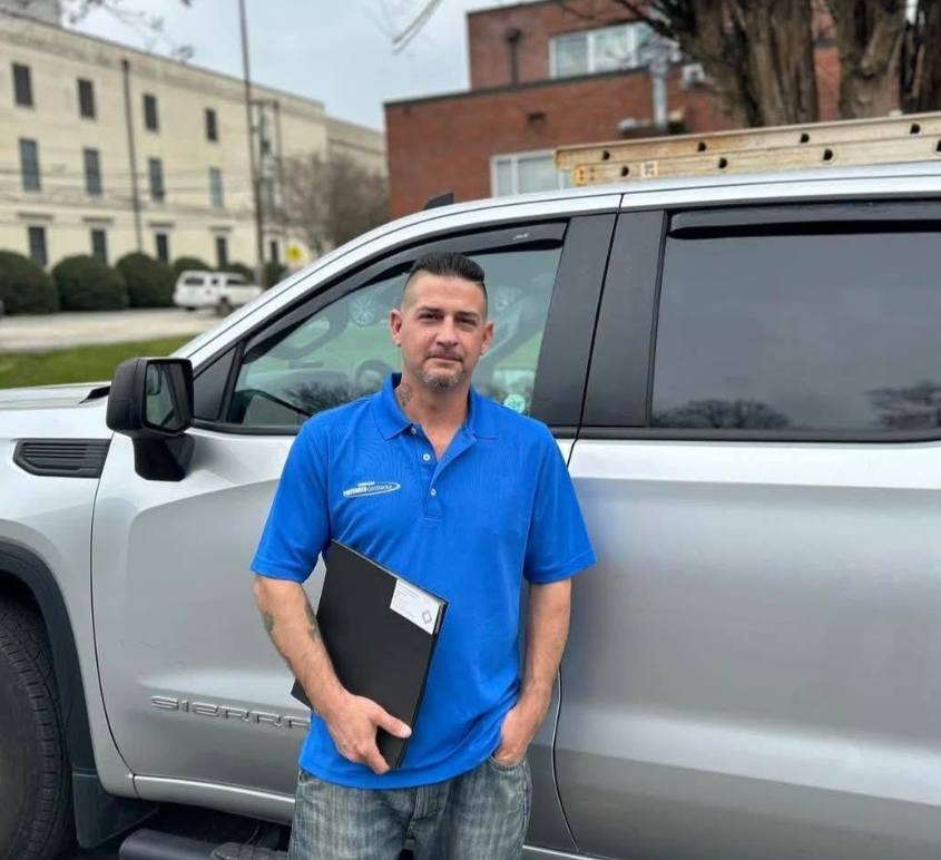 Owner of BYO Commercial Solutions standing in front of his GMC Sierra work truck